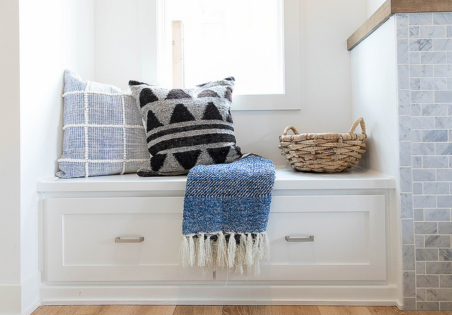 Stylish throw pillows and blanket on custom cabinetry. 